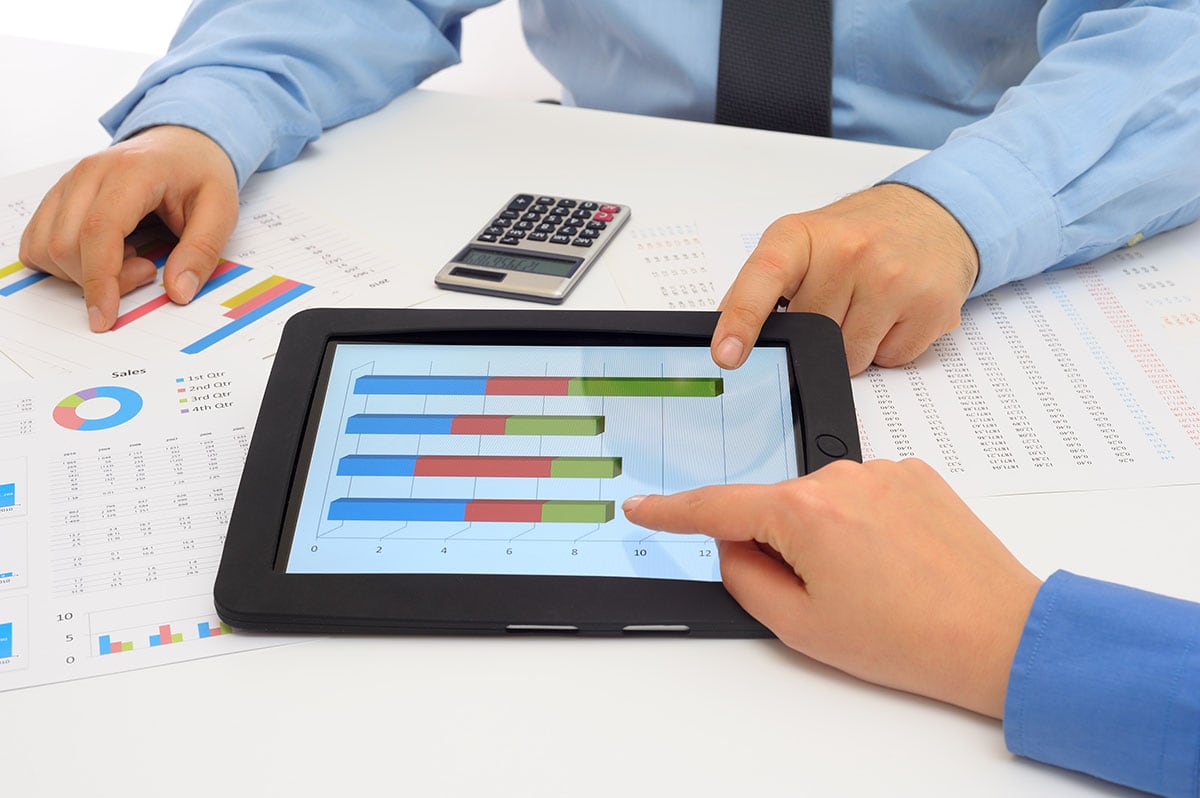 Businessman and businesswoman using digital tablet for the debt service coverage ratio formula